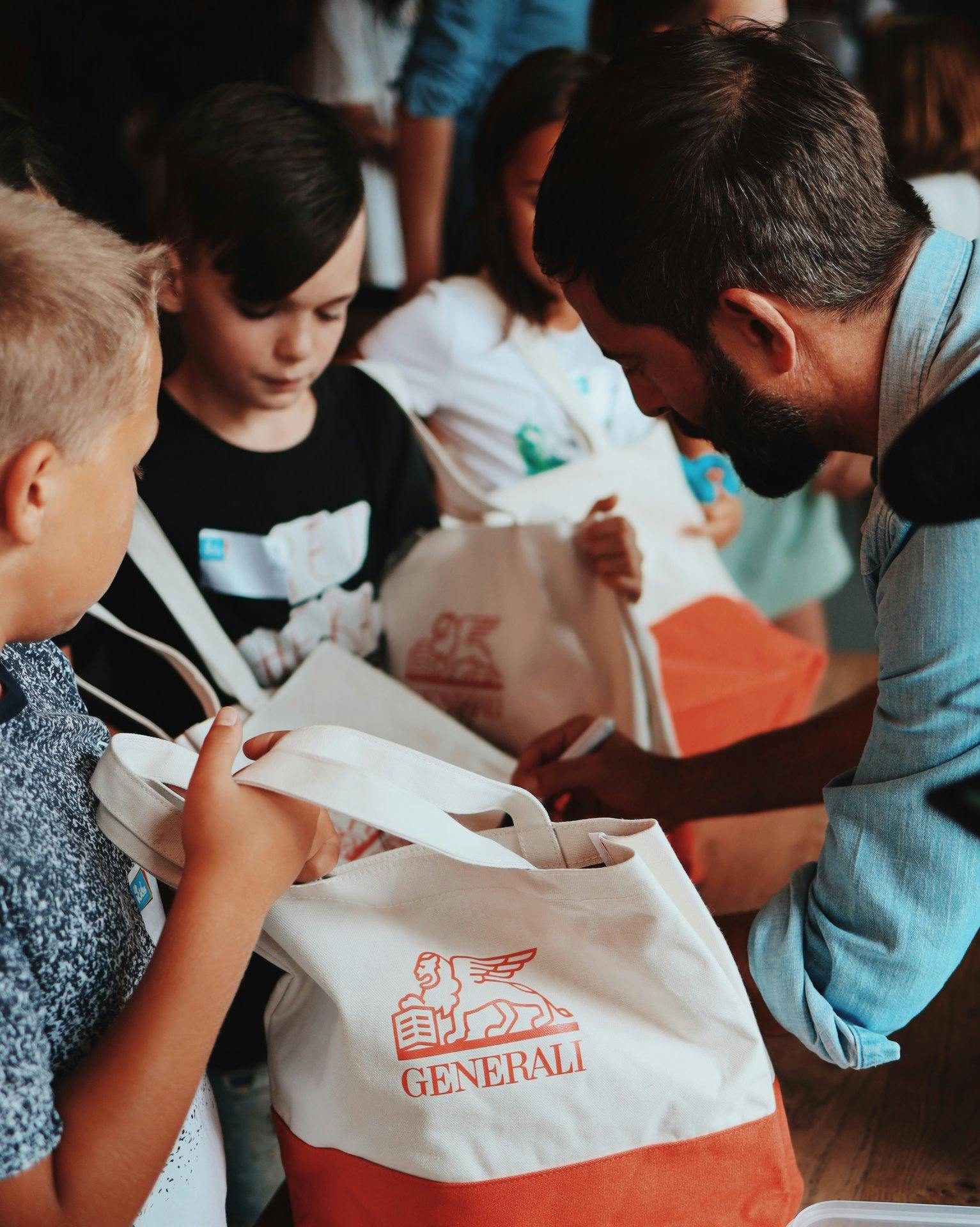 Bilgg unterschreibt die Goodie Bags  der Kinder.