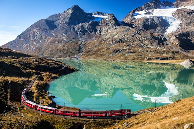 Warum denn in die Ferne schweifen, wenn man in der Schweiz ein Bahnlinie hat, die seit 2008 zum Unesco-Welterbe zählt? Eine Zugkomposition der Rhätischen Bahn kurvt um den Lago Bianco am Berninapass. Warum denn in die Ferne schweifen, wenn man in der Schweiz ein Bahnlinie hat, die seit 2008 zum Unesco-Welterbe zählt? Eine Zugkomposition der Rhätischen Bahn kurvt um den Lago Bianco am Berninapass.