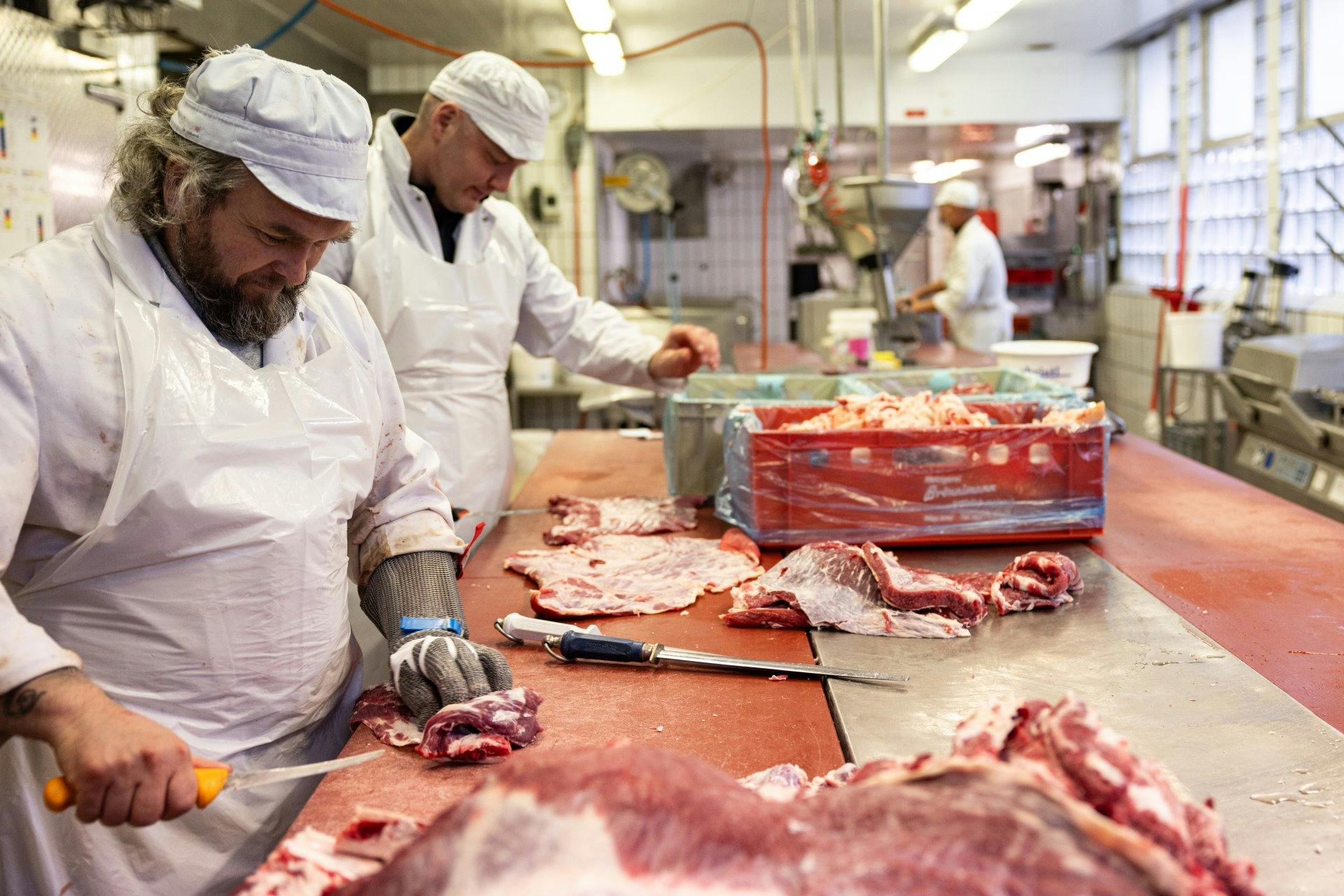 Die Zutaten für die Würste werden von Hand geschnitten und...