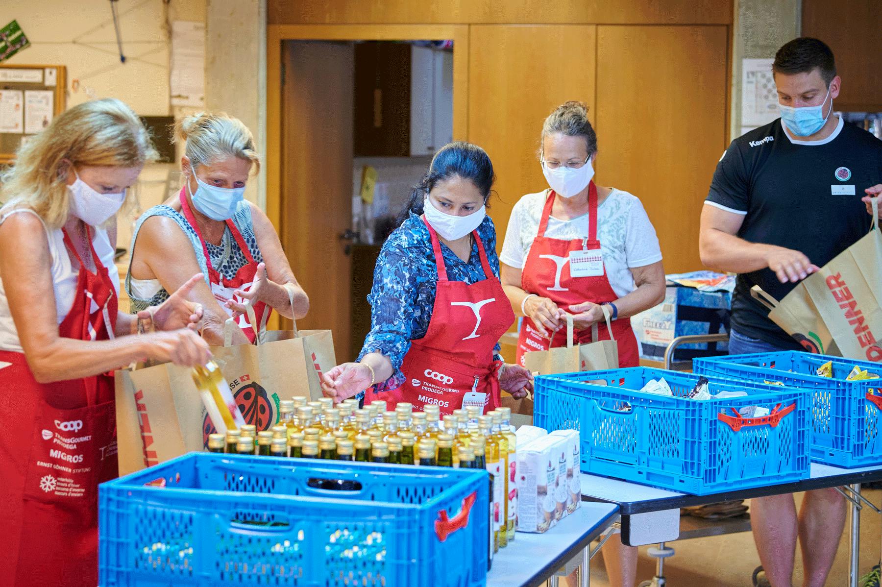 Gemeinsam mit den Schwingern Armon und Curdin Orlik verpacken Freiwillige von Tischlein deck dich die Lebensmittel, die anschliessend in der Abgabeste...