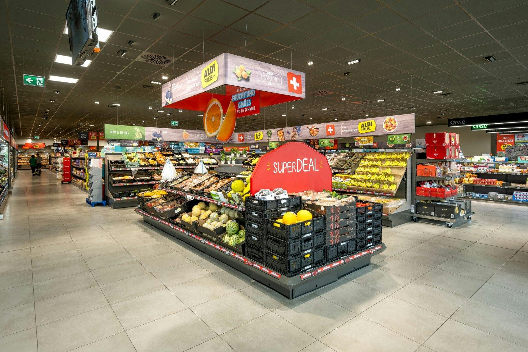 Uno spazio luminoso e invitante per frutta e verdura fresche in un supermercato Aldi. Mele fresche, verdure e specialità regionali sono messe in primo...