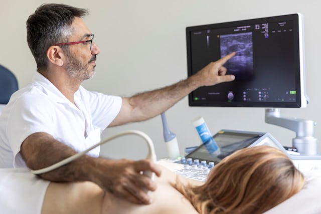 Dimitrios Zavitsanakis, leitender Arzt für Gynäkologie & Geburtshilfe, erklärt der Patientin, was auf dem Brust-Ultraschallbild zu erkennen ist.