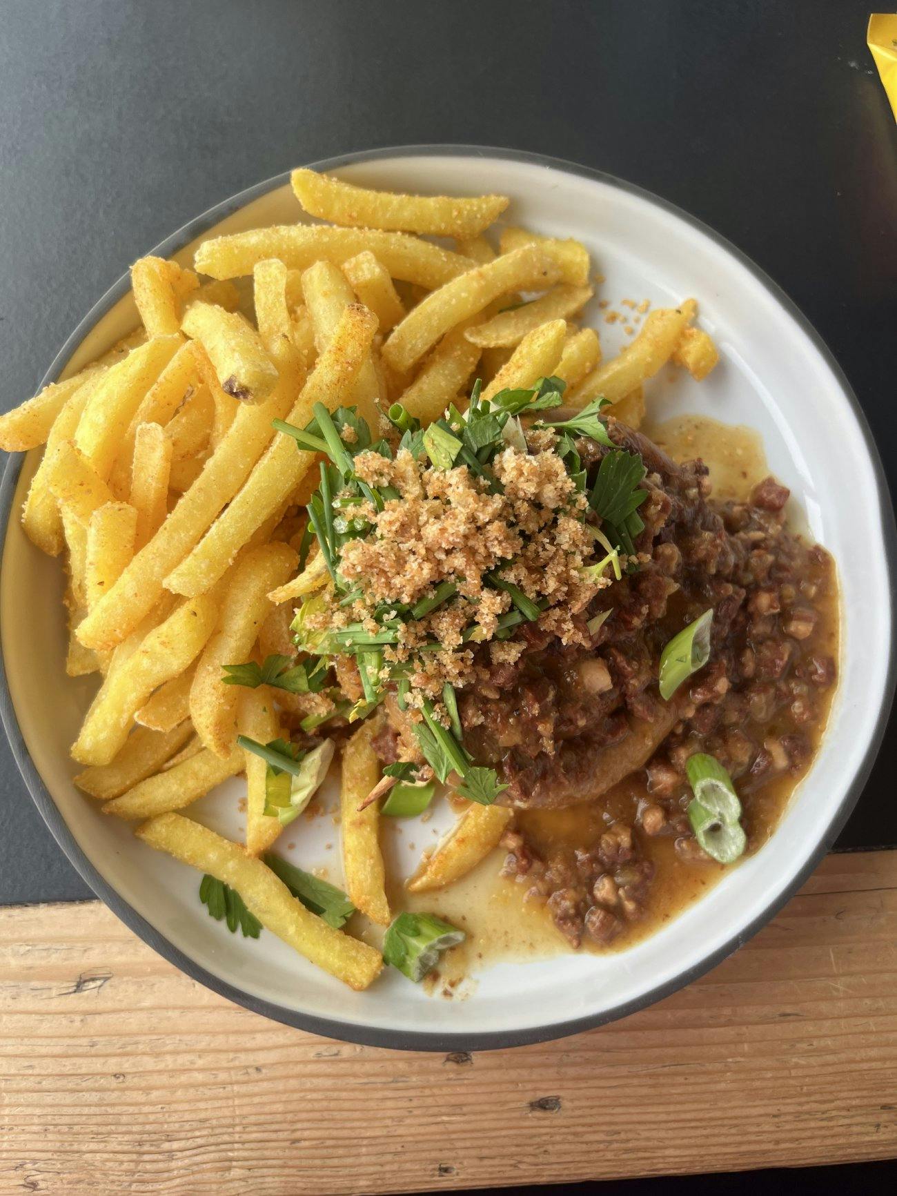 «Au menu ce midi: saucisse maison grillée avec sauce aux oignons et aux lardons, accompagnée de frites Allalin.»