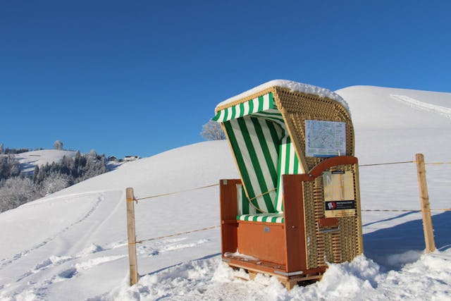 Geniesse eine Winterwanderung mit Aussicht: In Menzberg laden Strandkörbe über dem Nebelmeer zum Verweilen ein.