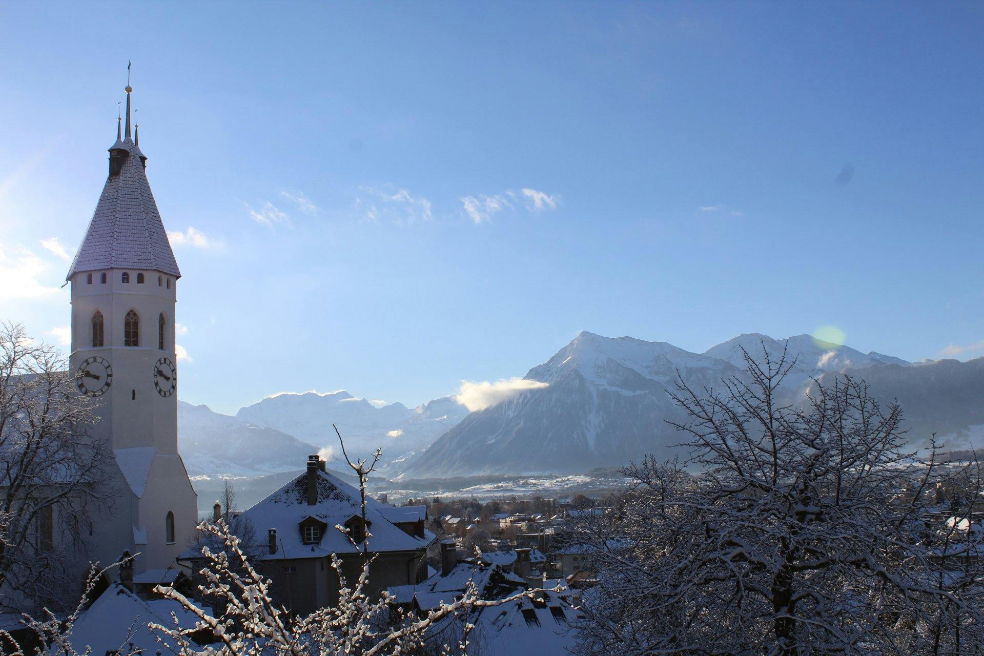 Der Winterzauber-Ausblick vom Schloss Thun reicht über die verschneiten Dächer bis zu den Alpen.