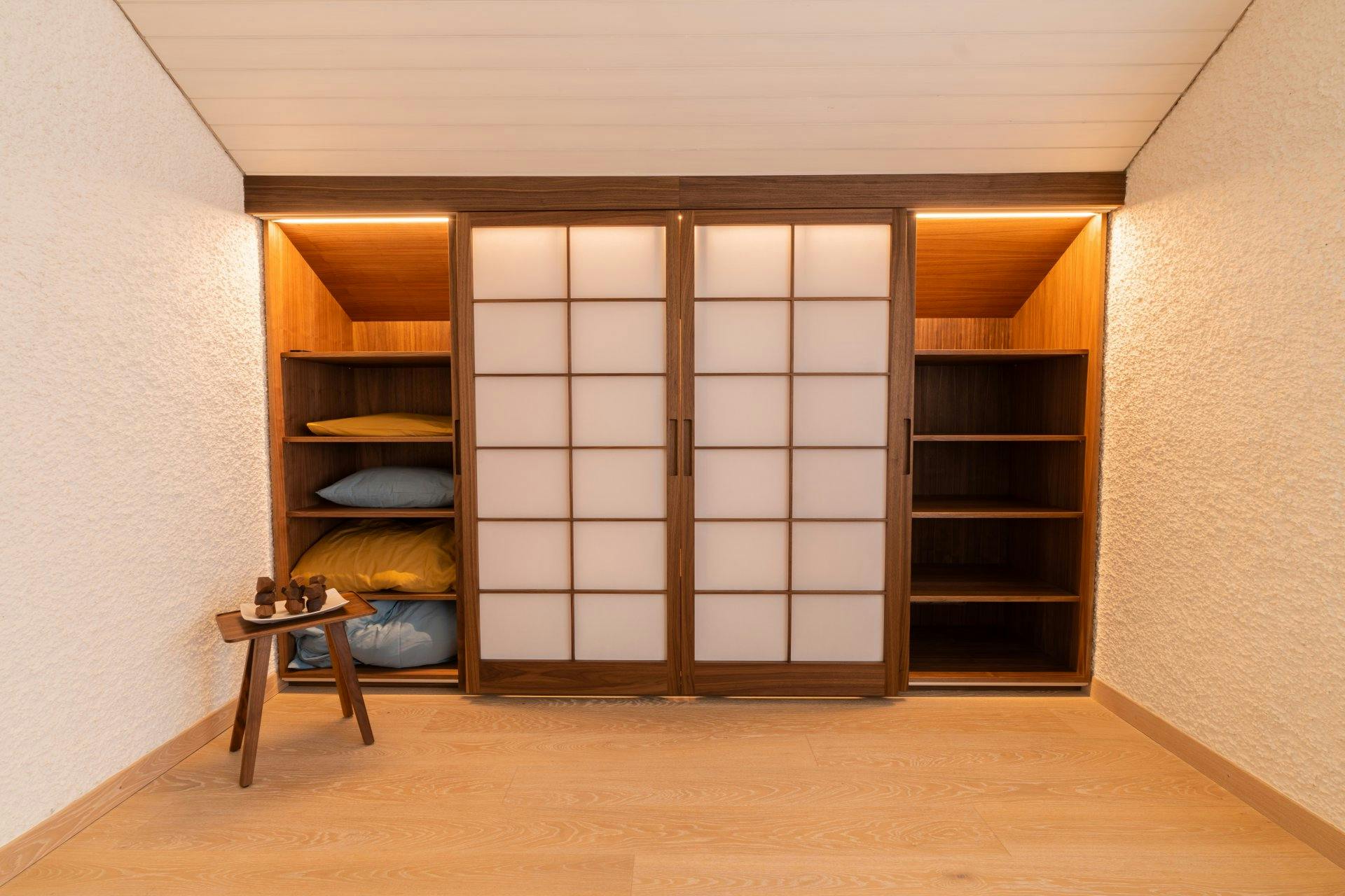 Hinter den Schiebetüren verbirgt sich viel Stauraum in Form von Regalen …