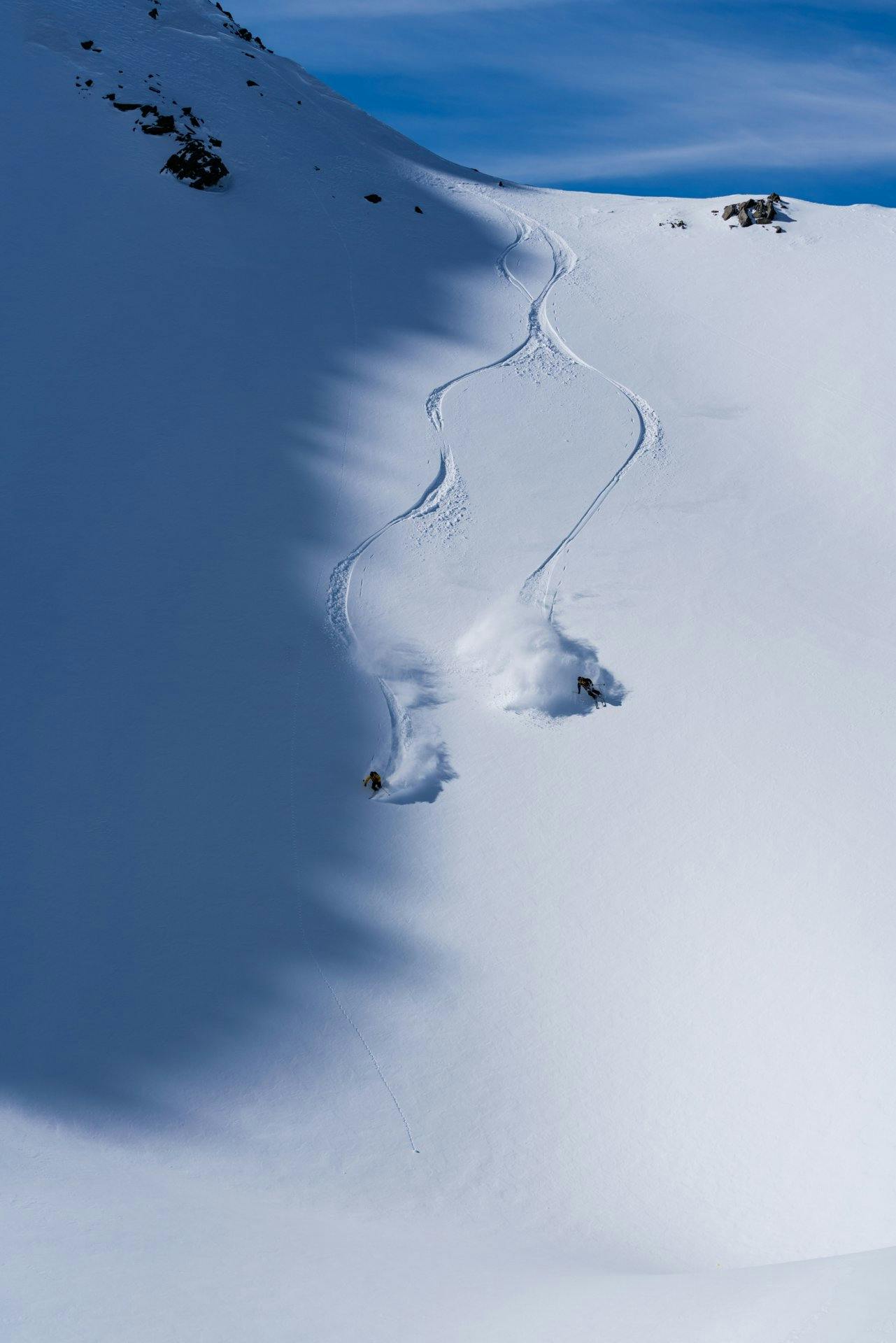 Freeriden bedeutet maximale Freiheit und mit der richtigen Ausrüstung auch maximale Sicherheit: Zwei Freerider zeichnen im Schnee ihre Spur.