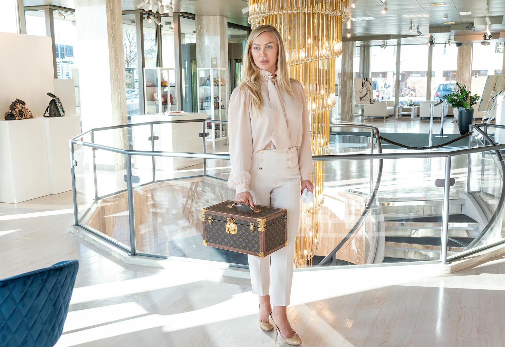 Beauty Case aus braunem Monogramm-Canvas mit Tragegriff.