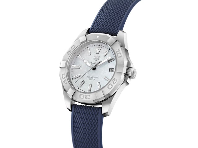 Die Uhr besticht durch ihre Eleganz mit einem weissen Zifferblatt aus natürlichem Perlmutt und einem feinen marineblauen Kautschukarmband.