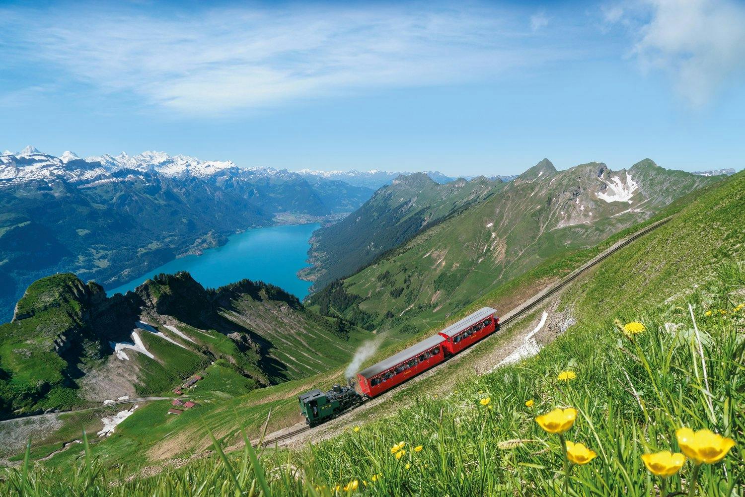 À vapeur: le train Brienz Rothorn gravit la montagne à toute vapeur. Le lac de Brienz brille comme une émeraude au fond de la vallée.