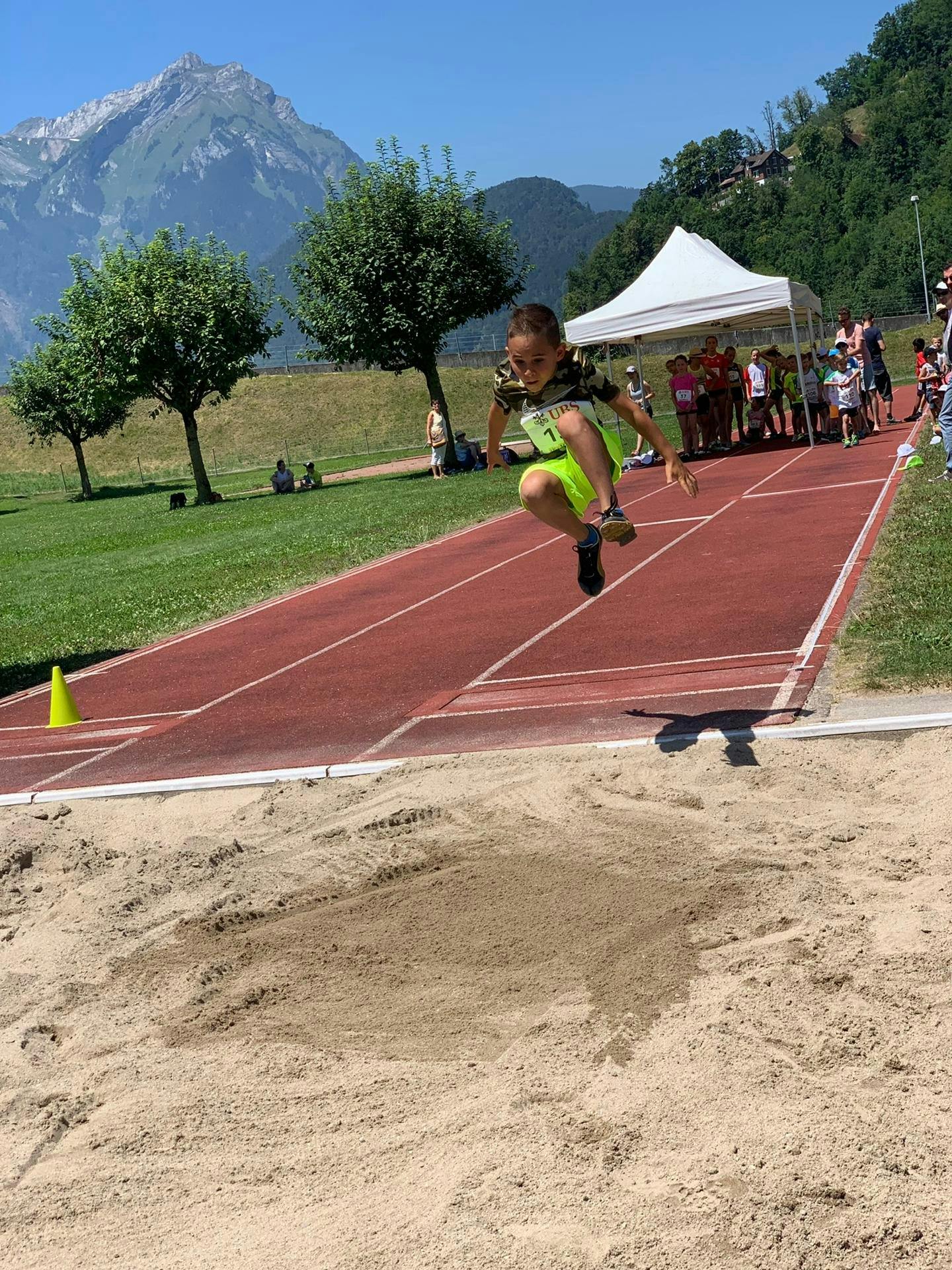 Sembra volare: il piccolo atleta dà il meglio di sé nel salto in lungo.