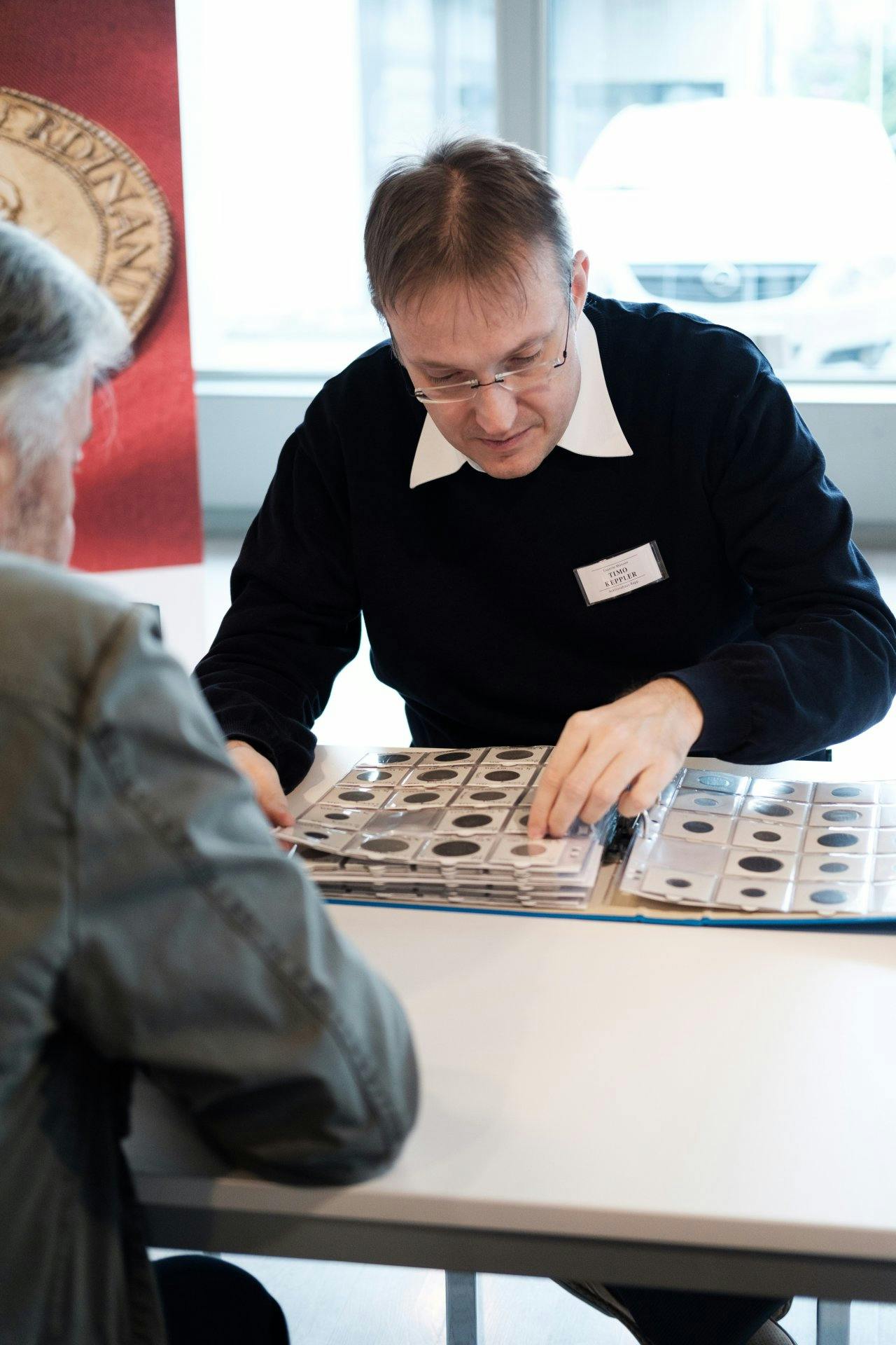 Ein Experte des Auktionshauses Rapp bei der Wertschätzung einer Münzsammlung.