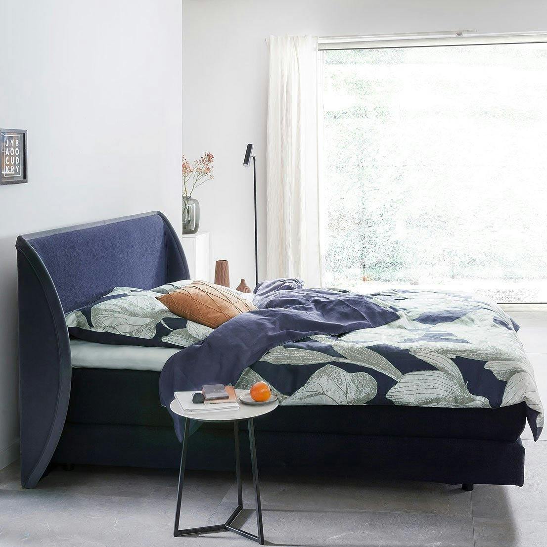 Das Designbett Brio mit geschwungenem Kopfteil.