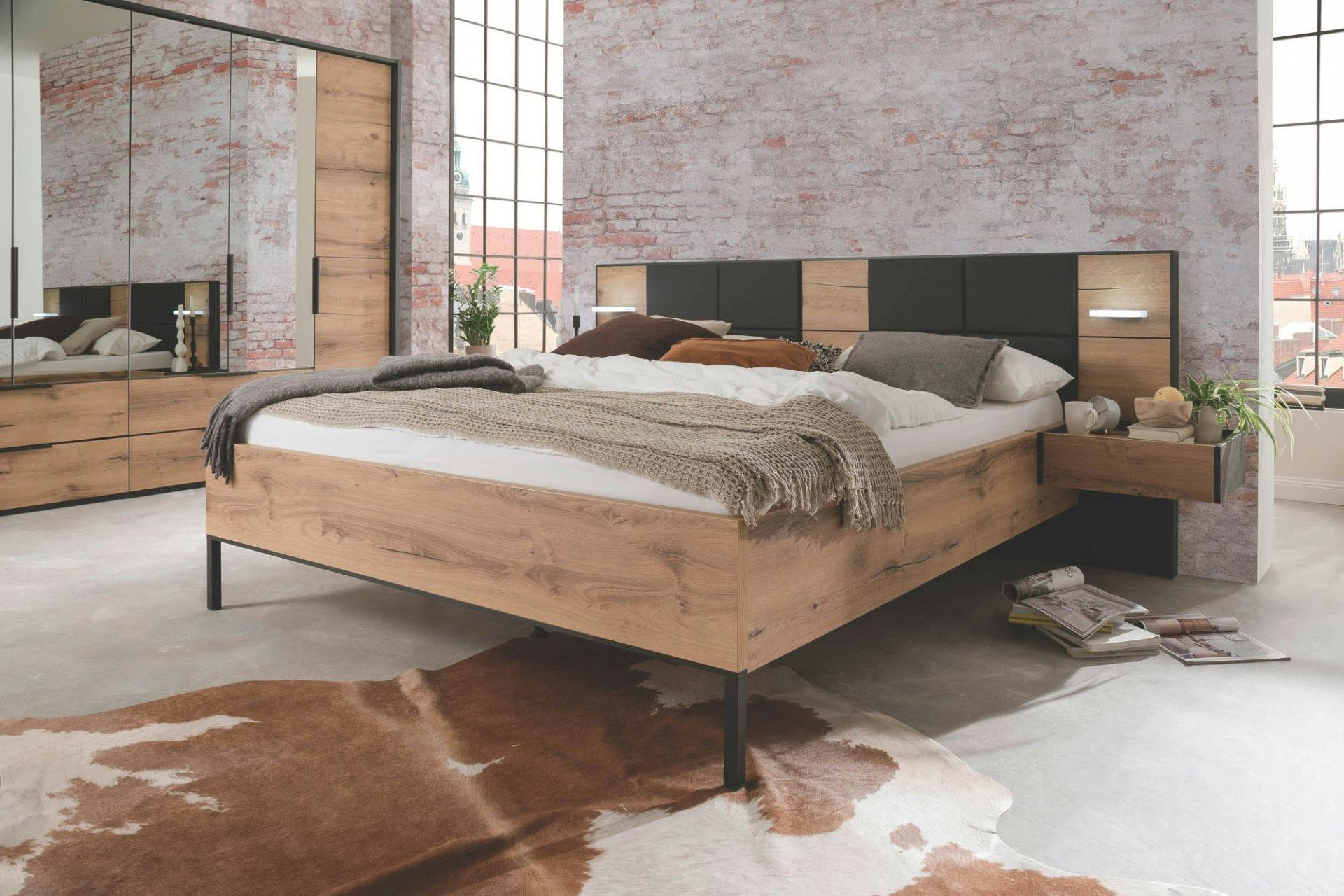 Bett Corby mit Polsterauflagen in schwarzer Lederoptik inklusive Beleuchtung.