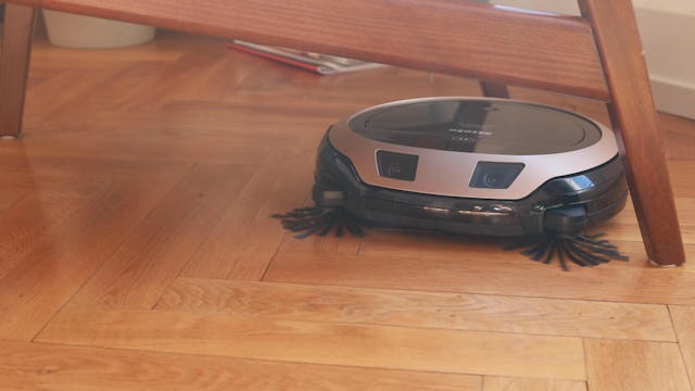 Le fauteuil du salon n'est pas un obstacle pour le Scout RX3 de Miele.