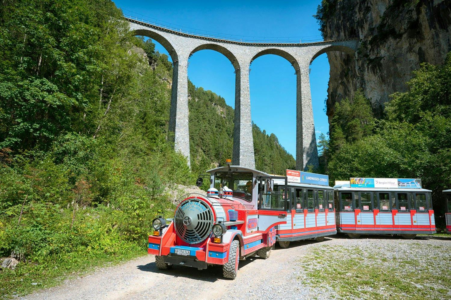Die Route des Hop-on-Hop-off-Zugs führt durch das paradiesische Dorf Filisur und entlang der beiden Bäche bis zum Viaduktplatz.