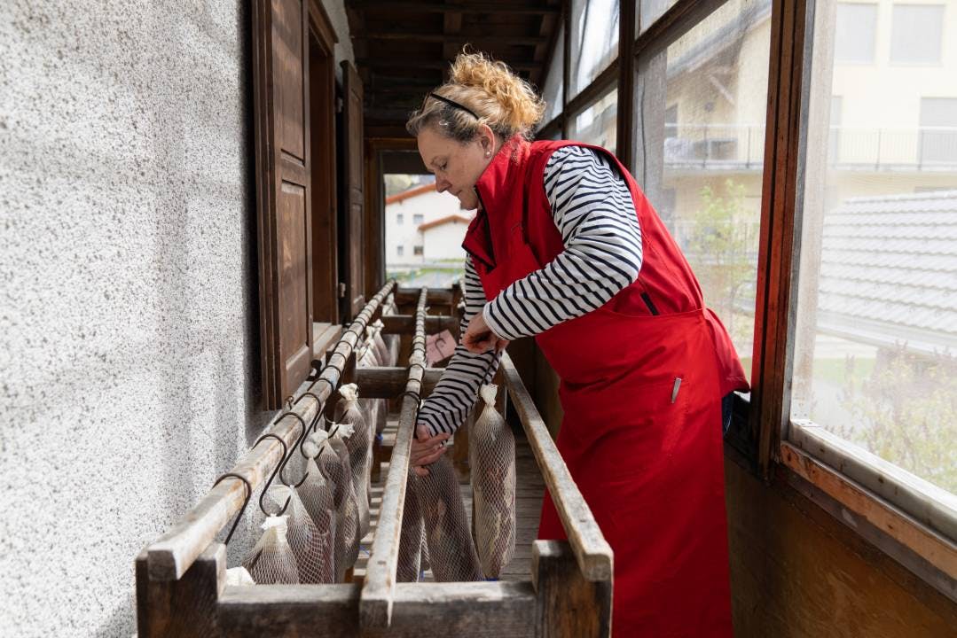 Jacqueline Eberle, die bei Bischi auch für Administration, Verkauf und Buchhaltung zuständig ist, hängt Bündnerfleisch zum Trocknen auf.