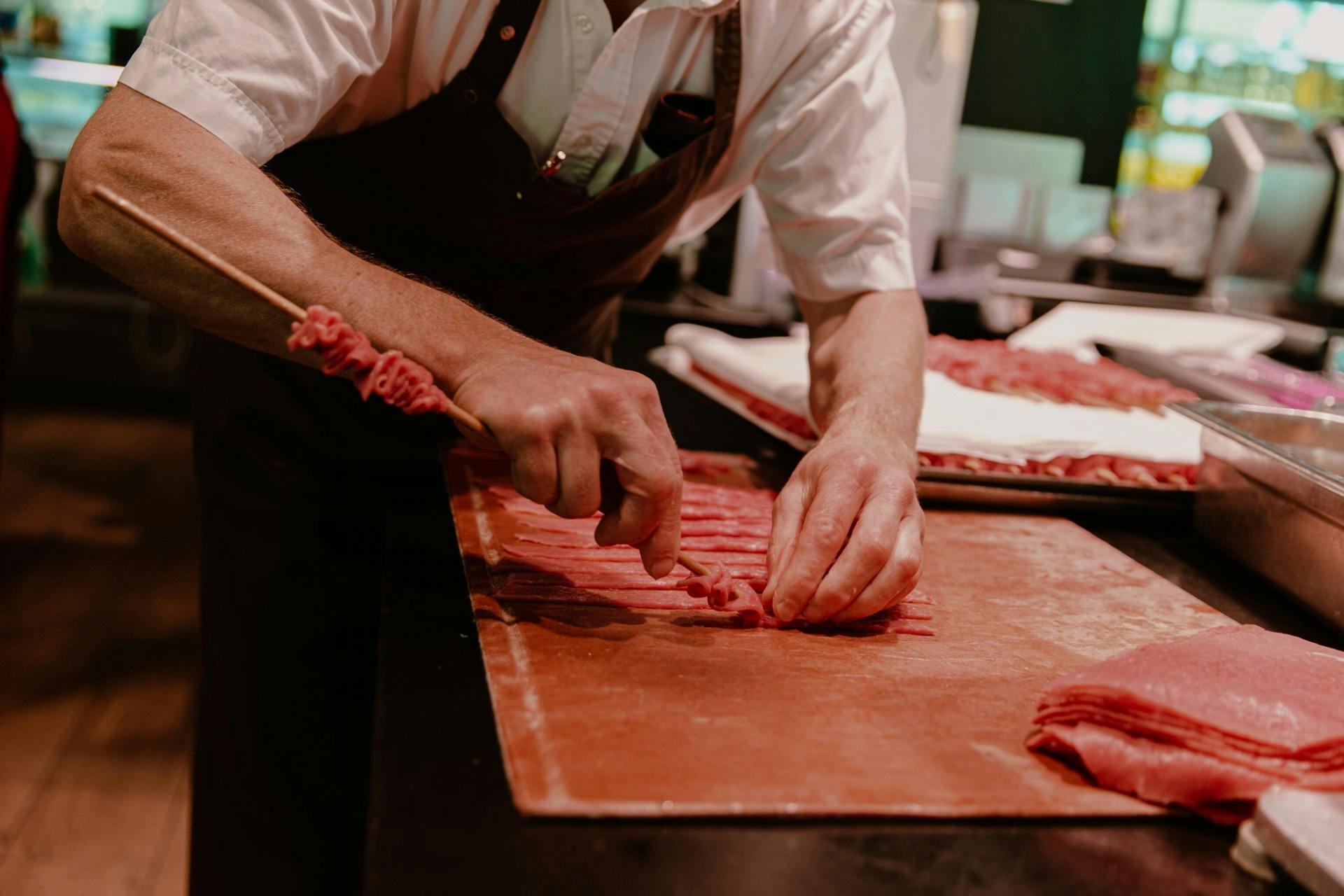 Travail manuel: pour une brochette juteuse, la viande de veau est coupée en fines tranches et posée finement sur des piques.